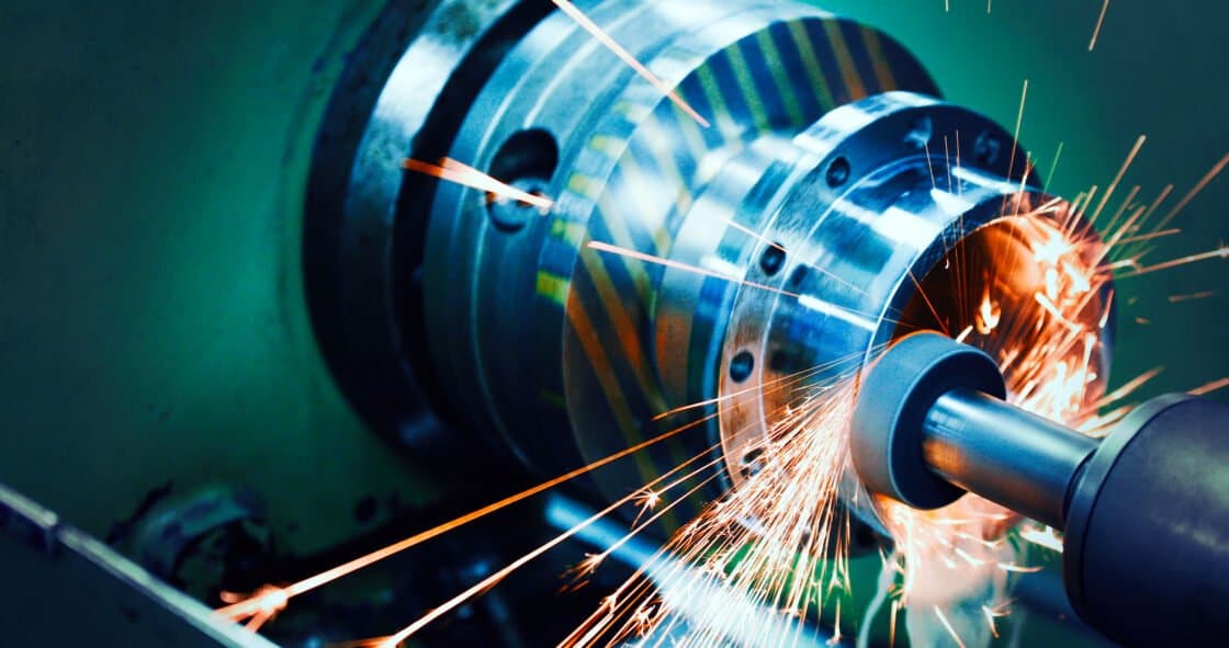 Sparks flying from a grinding machine on a manufacturing floor